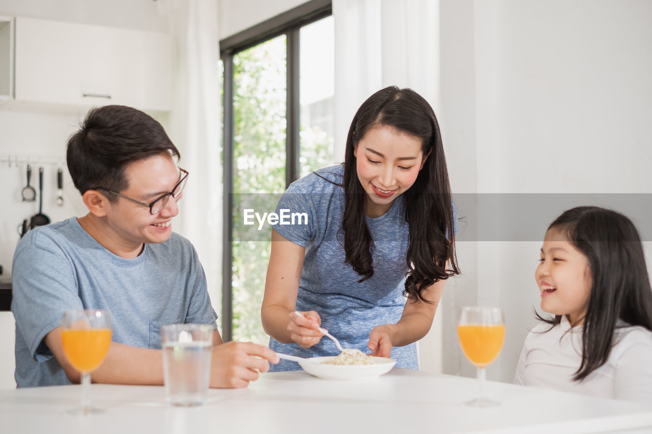 Smiling family having breakfast at home