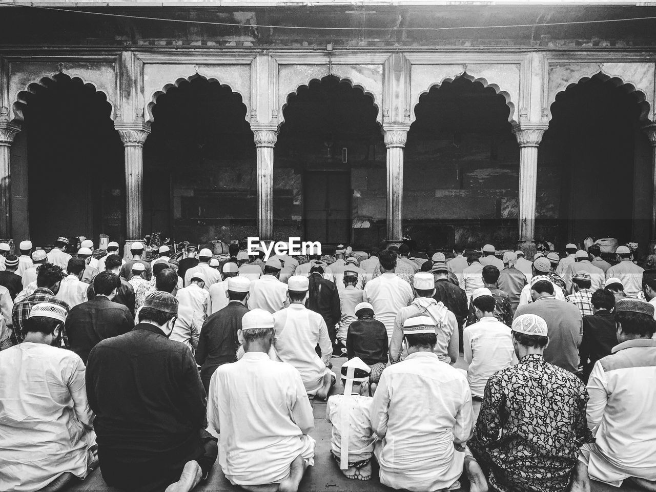 Rear view of crowd praying at mosque