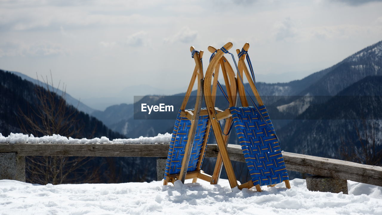 TRADITIONAL WINDMILL ON FIELD AGAINST SNOWCAPPED MOUNTAINS