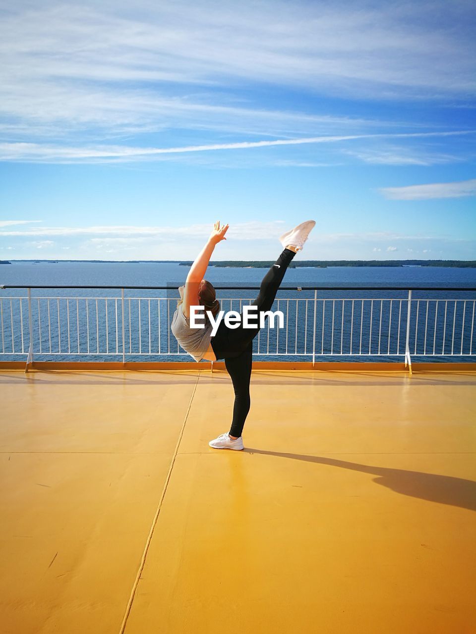 YOUNG WOMAN JUMPING ON RAILING