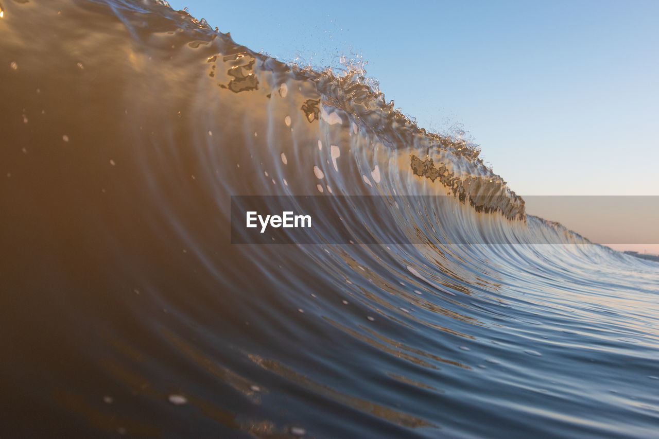 Close-up of water splashing on land against sky