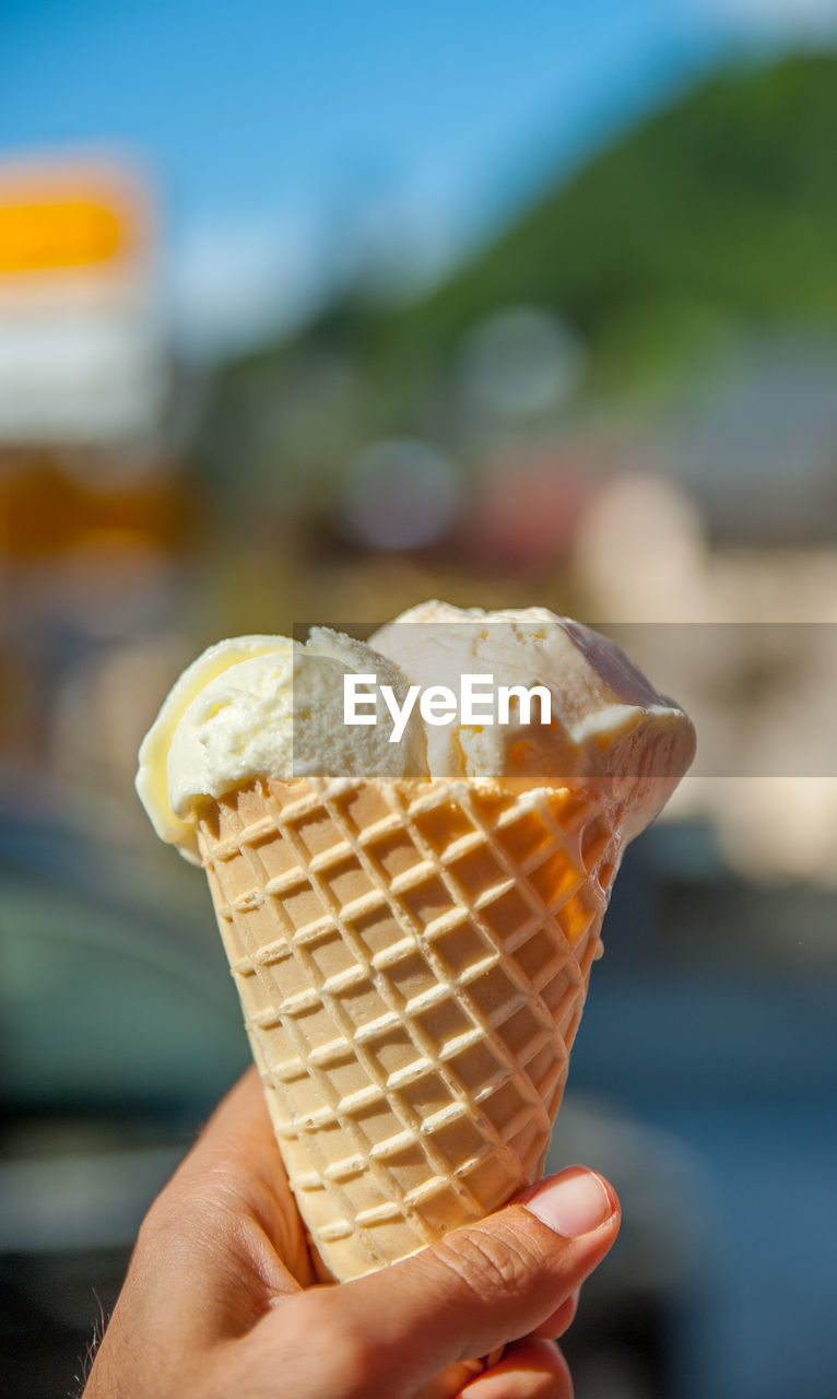 CROPPED HAND HOLDING ICE CREAM CONE