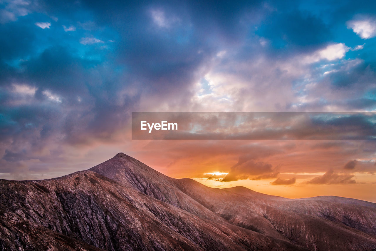 Scenic view of mountains against sky at sunset