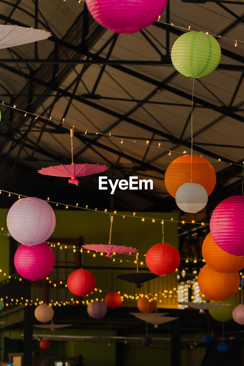 Low angle view of colorful illuminated lanterns hanging on ceiling