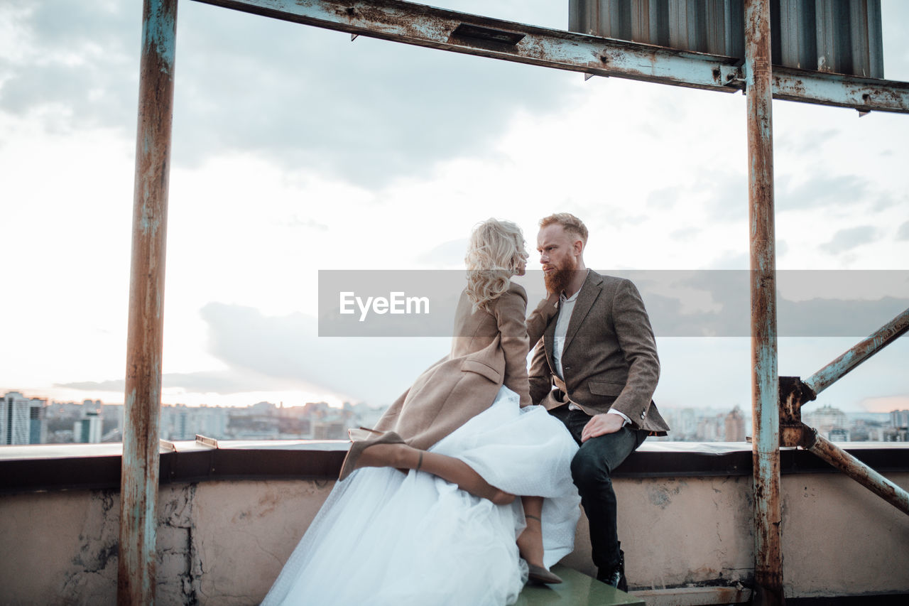 Rear view of couple kissing against sky