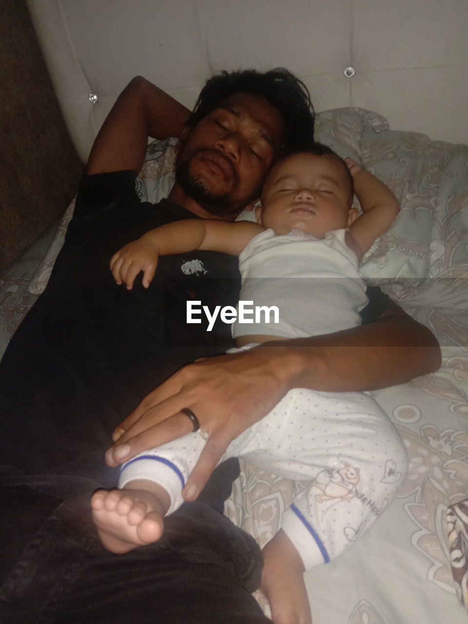 HIGH ANGLE VIEW OF FATHER AND BABY ON BED