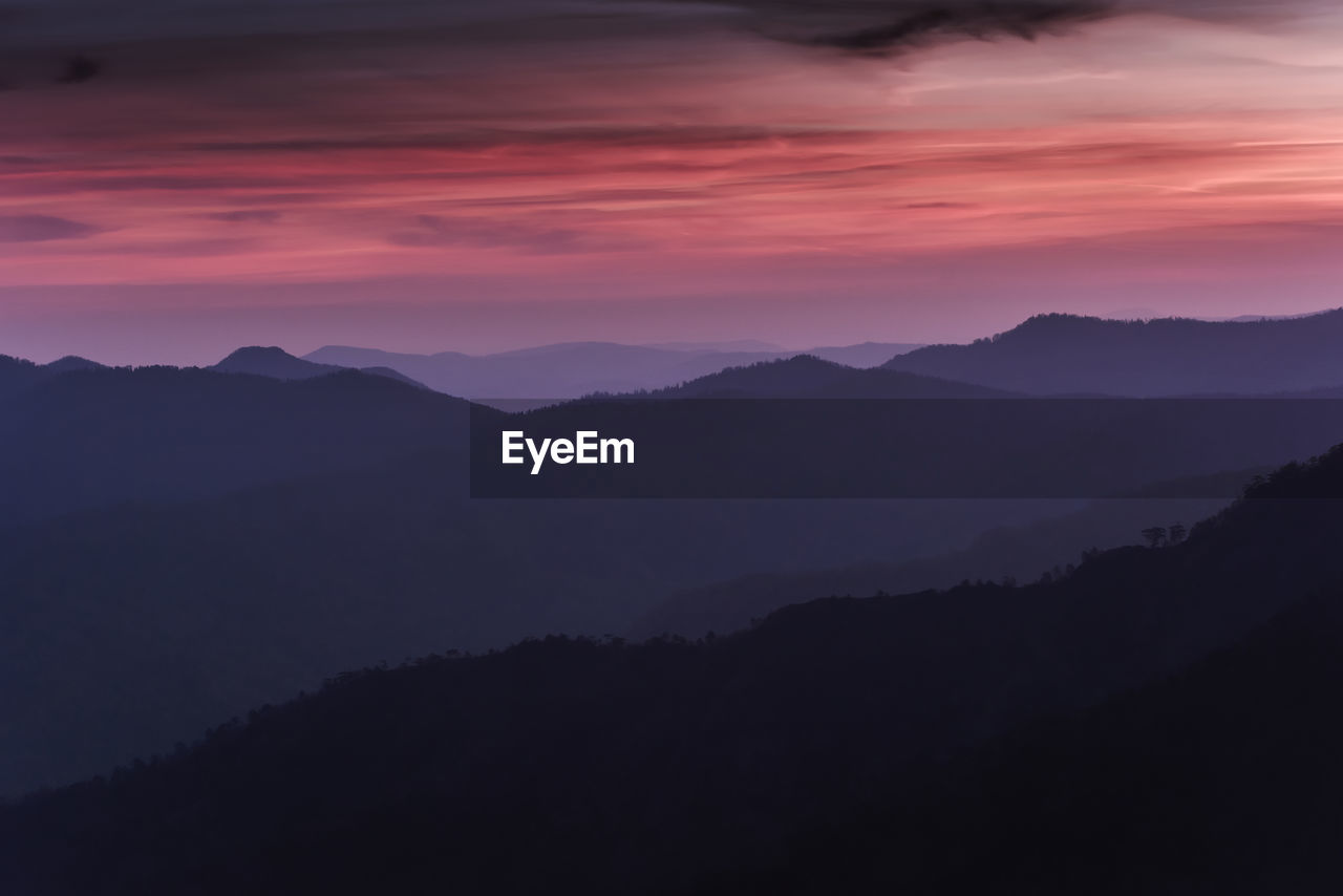 scenic view of silhouette mountains against sky at sunset