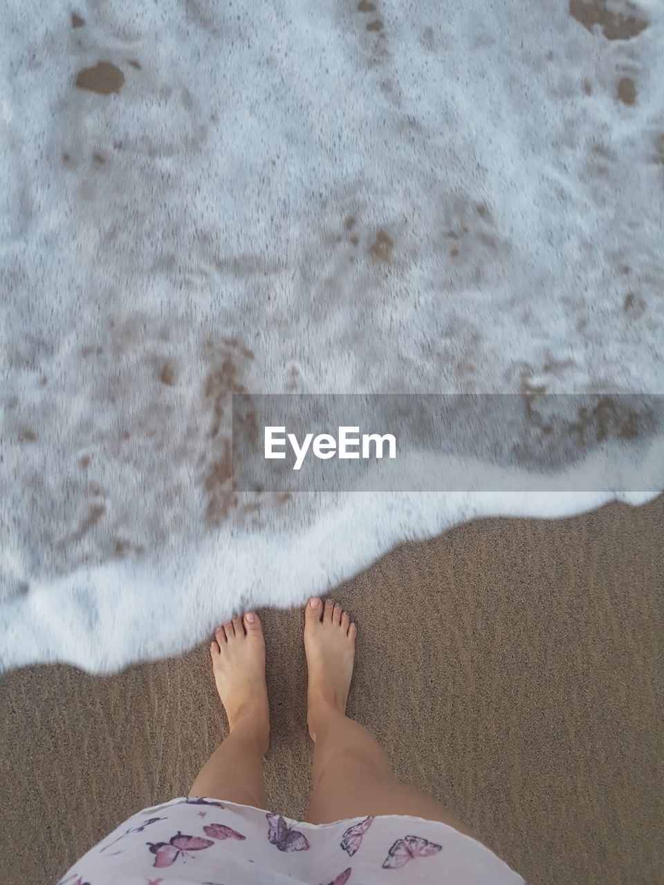 Low section of woman relaxing on beach