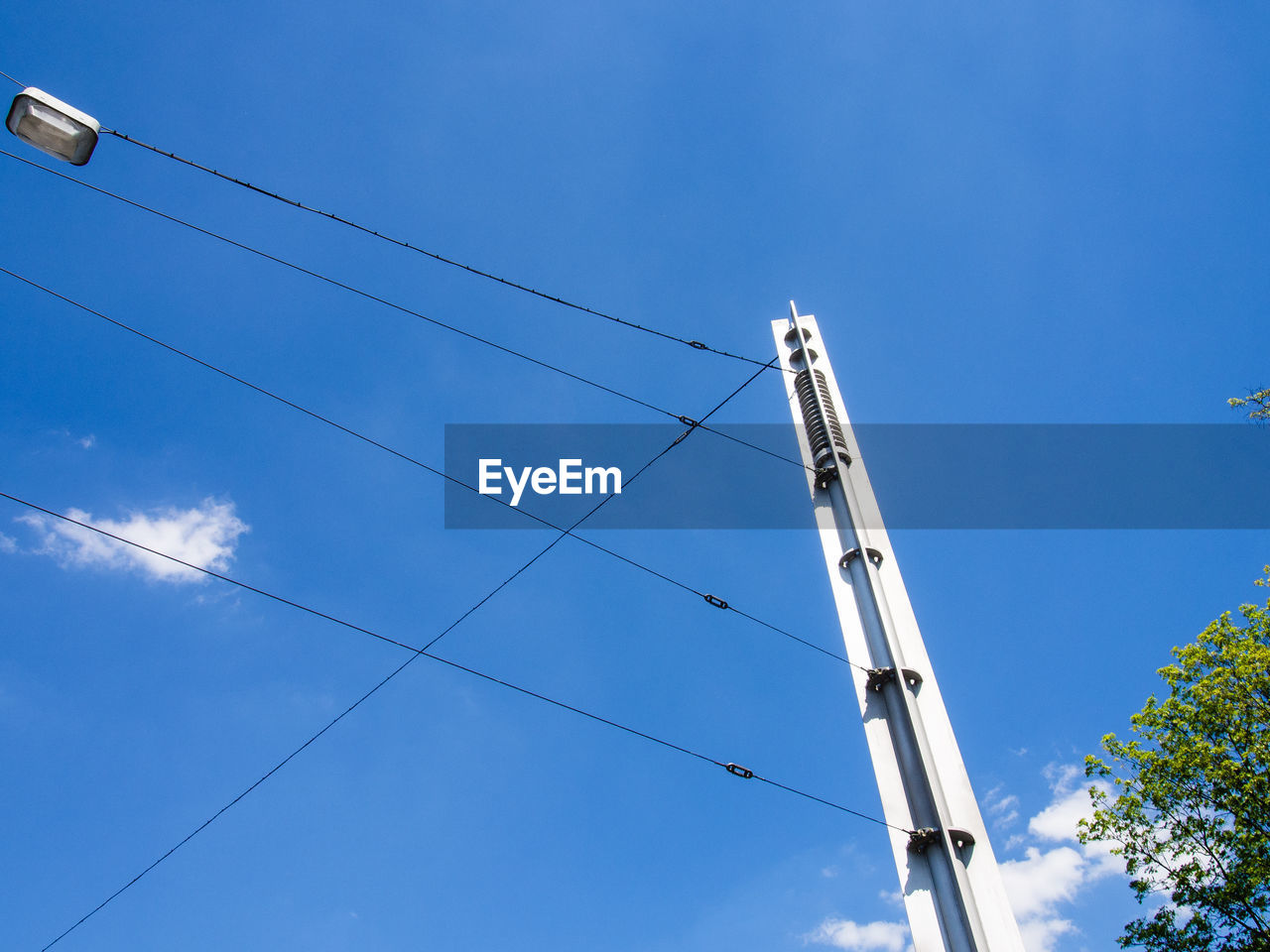 Low angle view of electricity pylon against blue sky