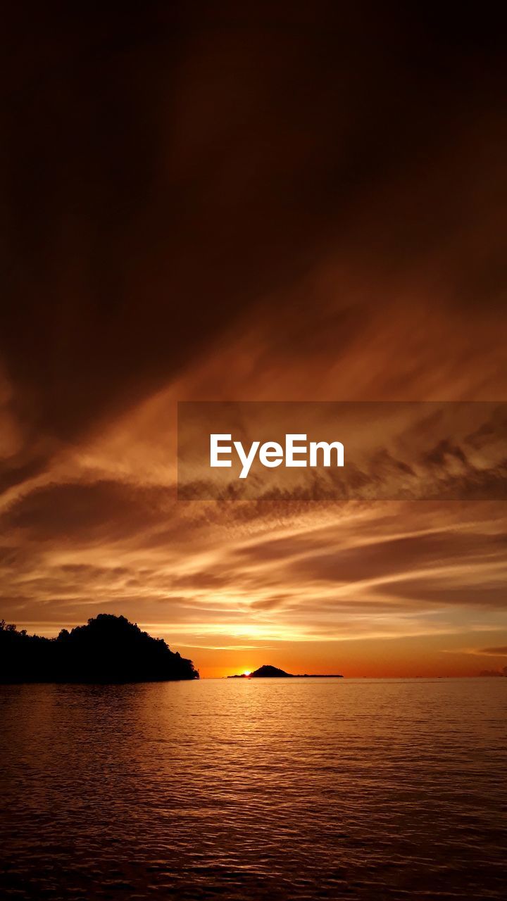SCENIC VIEW OF SEA AGAINST ORANGE SKY