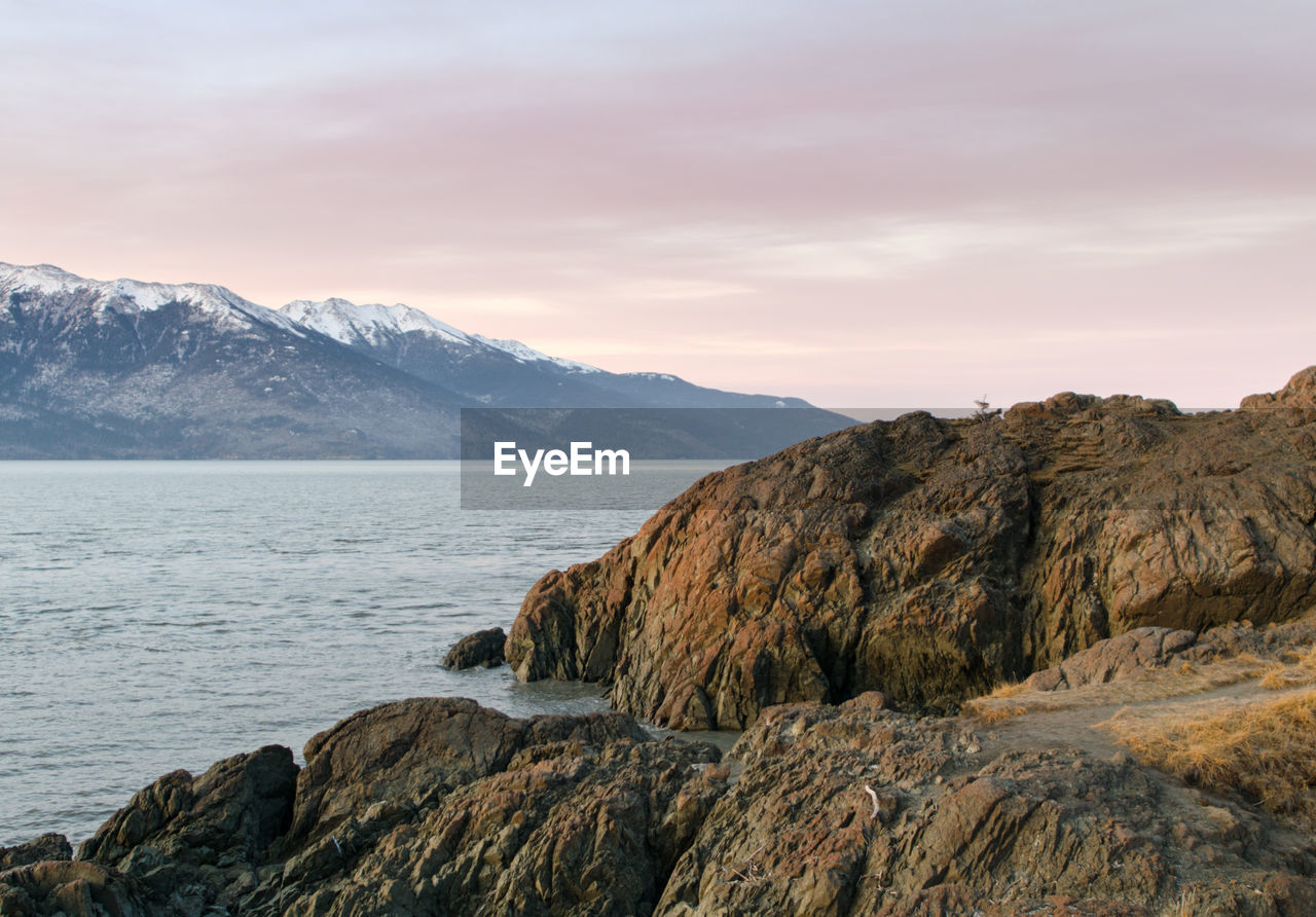 Scenic view of sea and mountains against sky