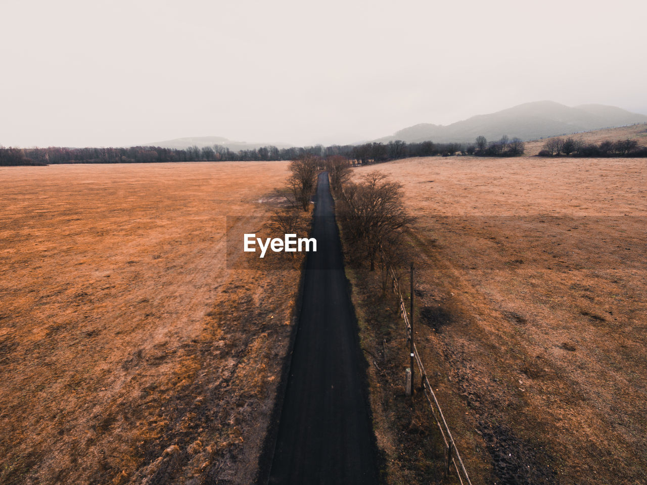 High angle view of road amidst field against clear sky