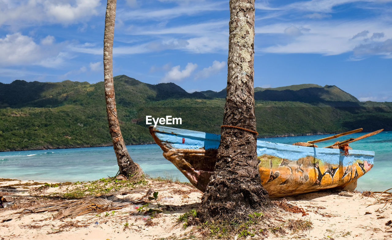 FISHING BOAT ON SHORE AGAINST SKY