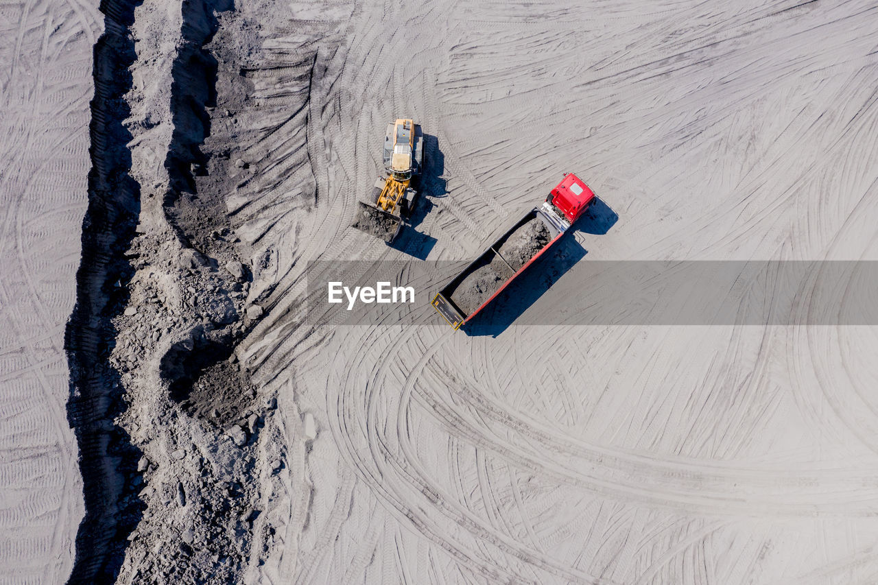 Aerial view of sand quarry with trucks and bulldozers. heavy bulldozer loading sand,