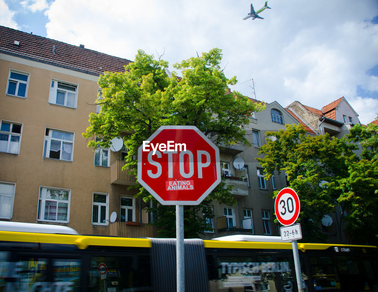 Low angle view of stop sign against building in city