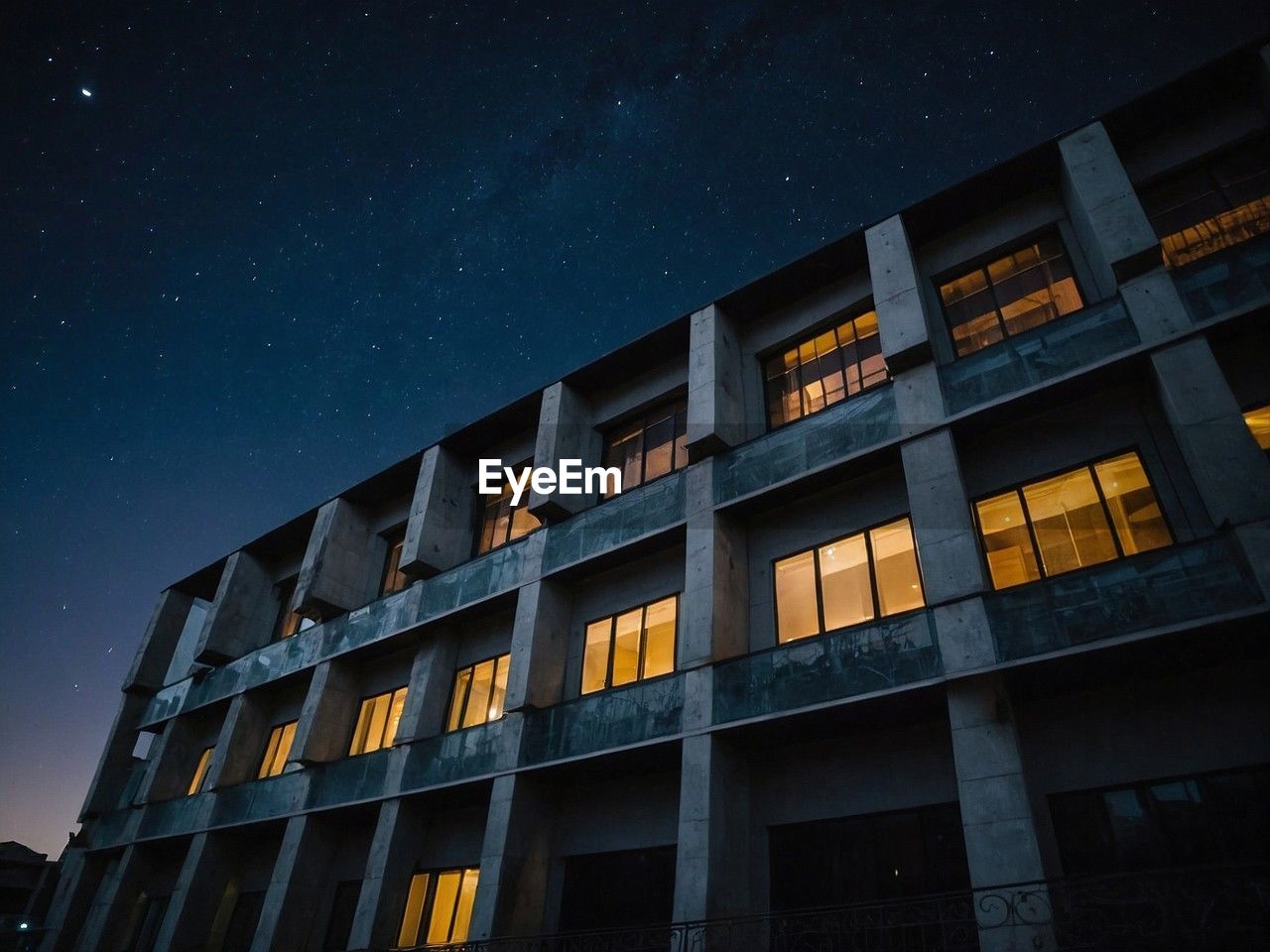 low angle view of modern building against sky at night