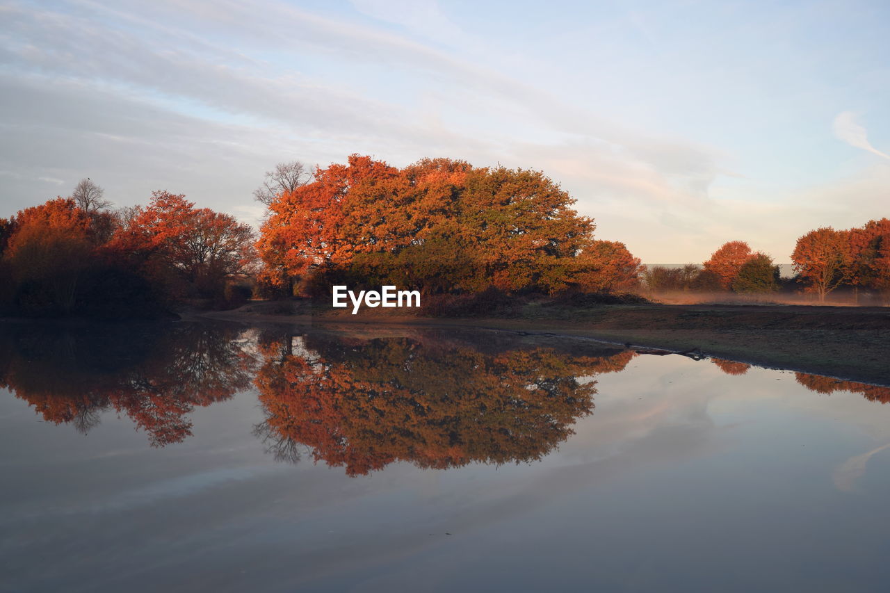 Reflection of trees in lake against sky during autumn