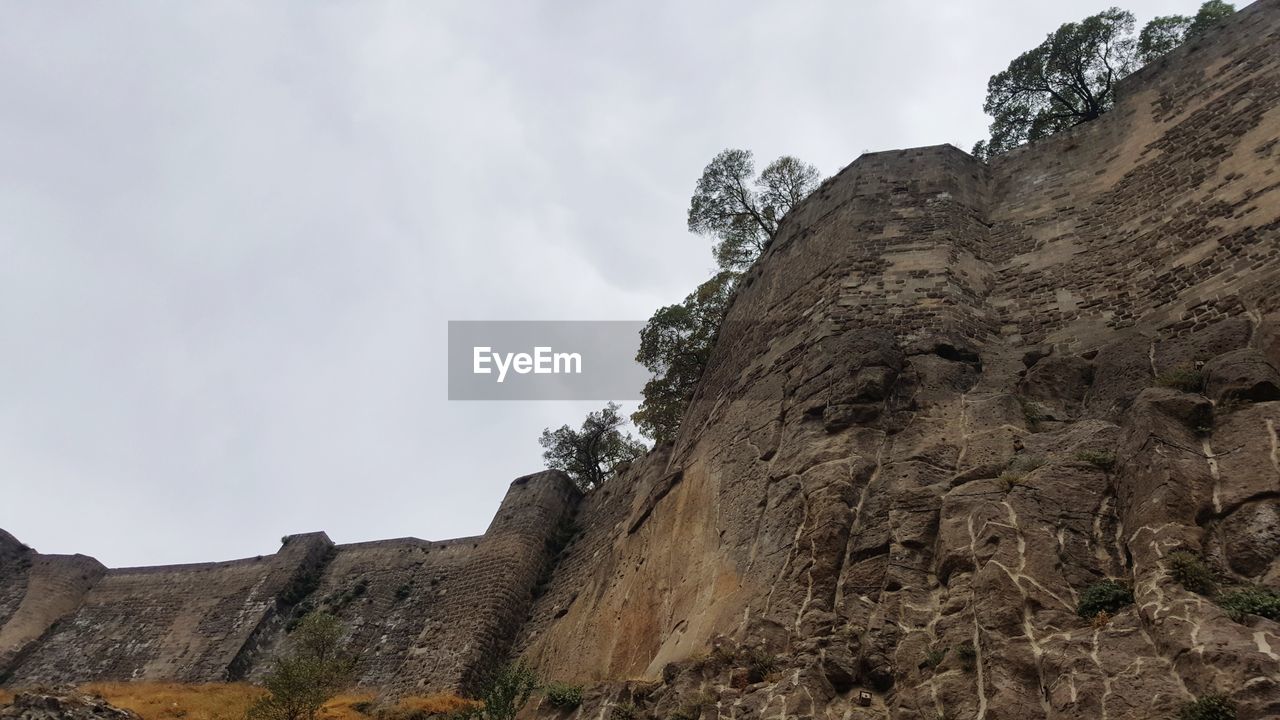 LOW ANGLE VIEW OF ROCK FORMATIONS AGAINST SKY