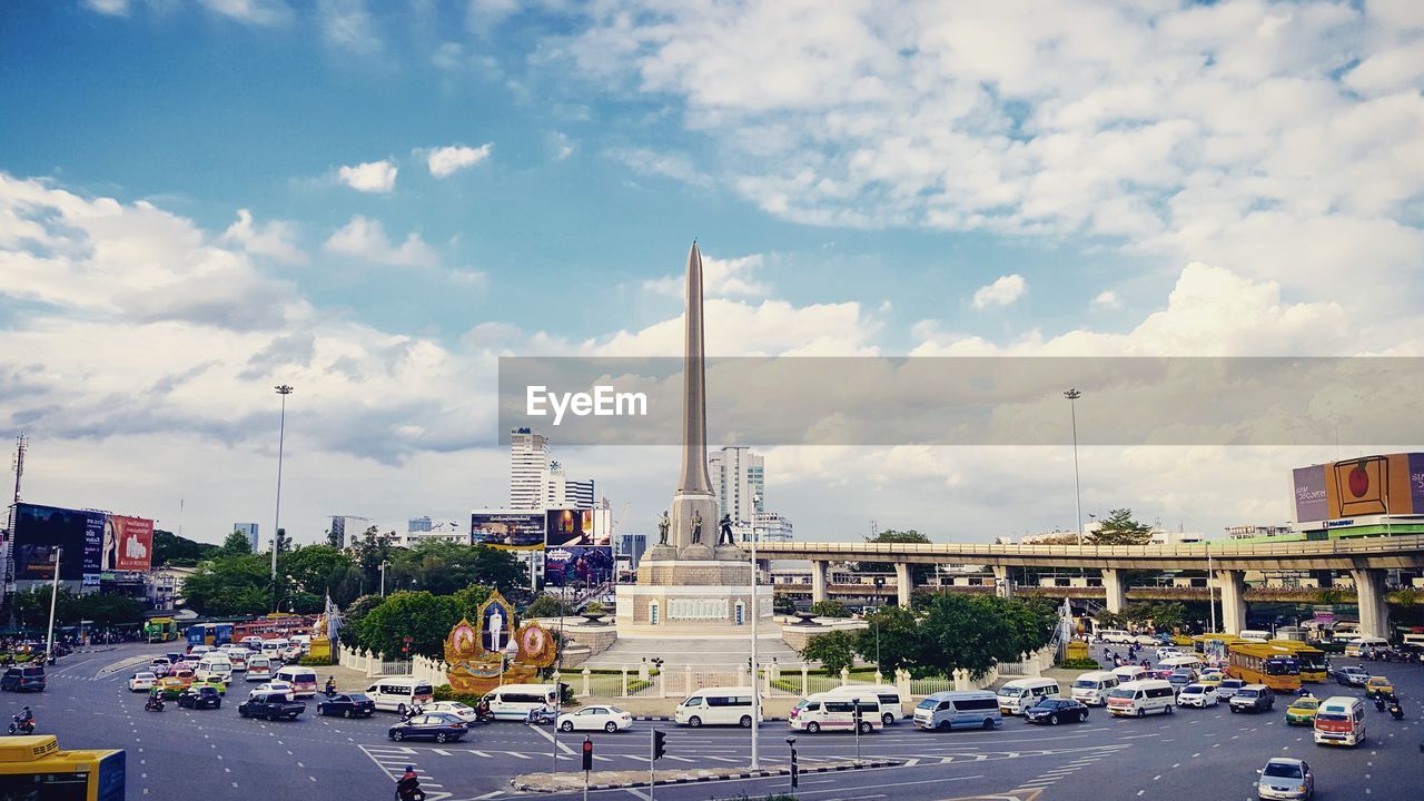 City street by victory monument against sky