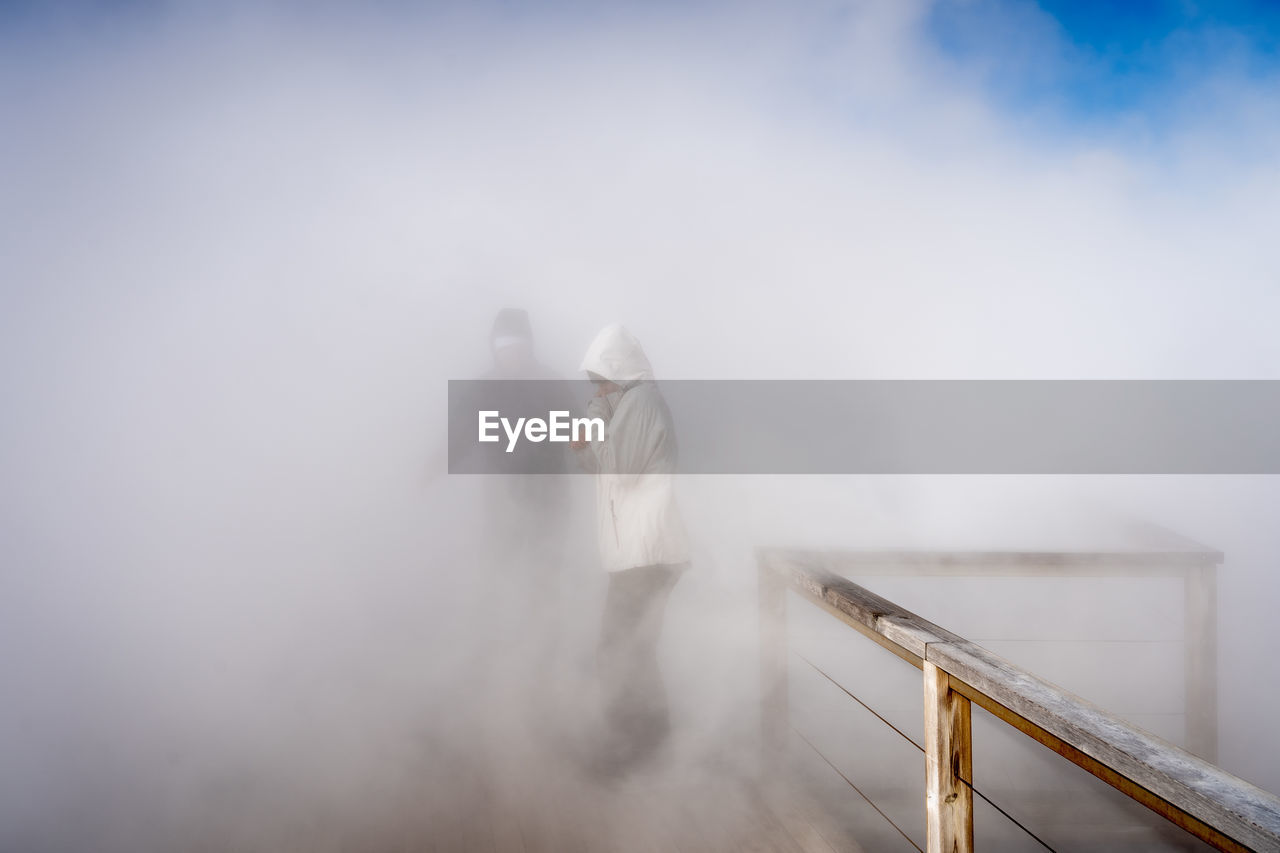 fog, morning, sky, adult, smoke, cloud, sunlight, white, men, nature, mist, standing, blue, day, architecture, copy space, winter, two people, reflection, outdoors, railing, women, occupation, young adult, communication