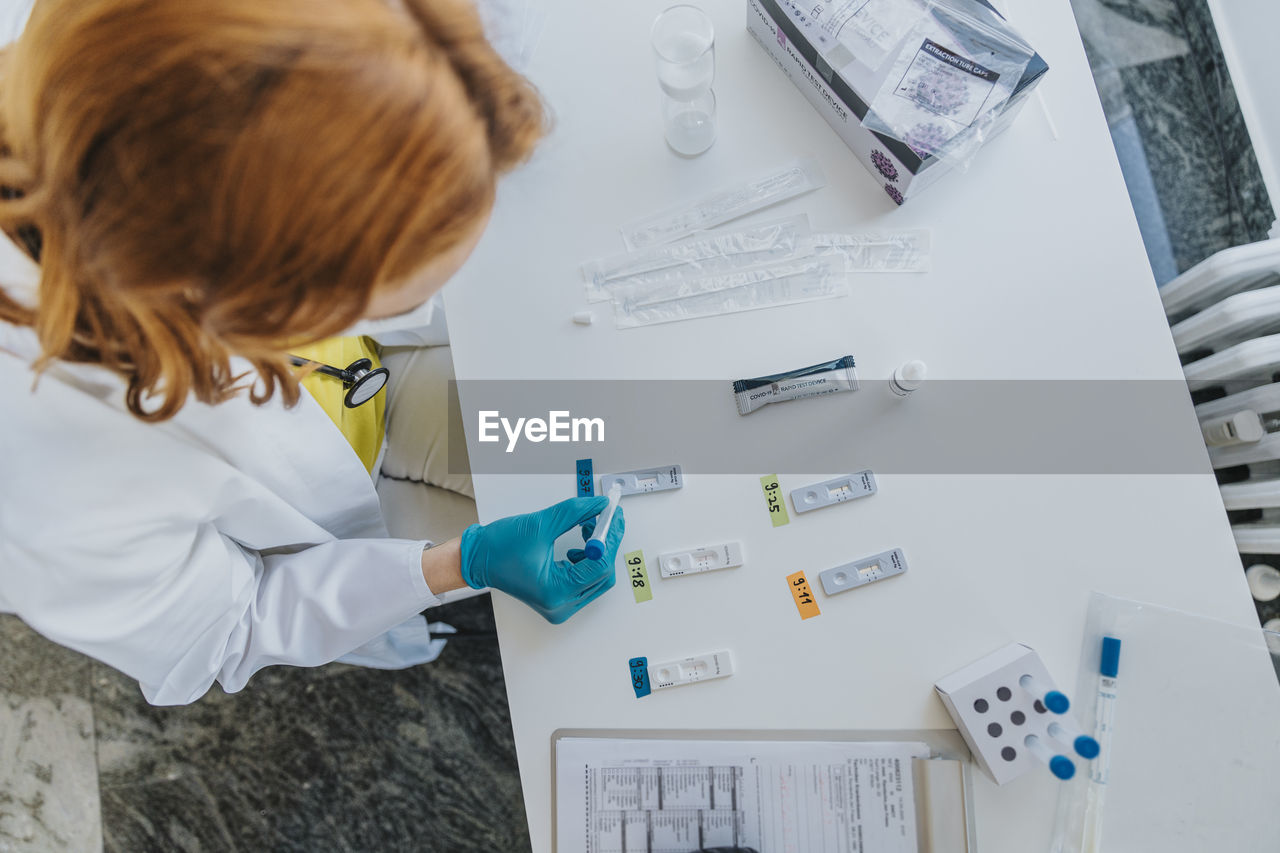 Female general practitioner doing medical sample rapid diagnostic test at examination room