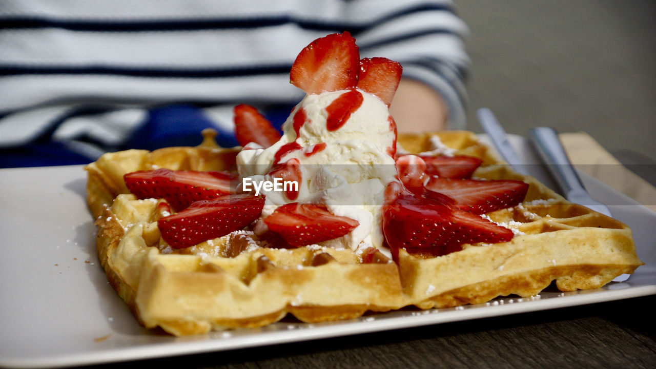 food, food and drink, meal, fruit, belgian waffle, dish, breakfast, sweet food, freshness, dessert, waffle, sweet, berry, plate, strawberry, healthy eating, produce, pavlova, cake, indoors, baked, temptation, close-up, one person, dairy, fast food, table, slice, cuisine, focus on foreground