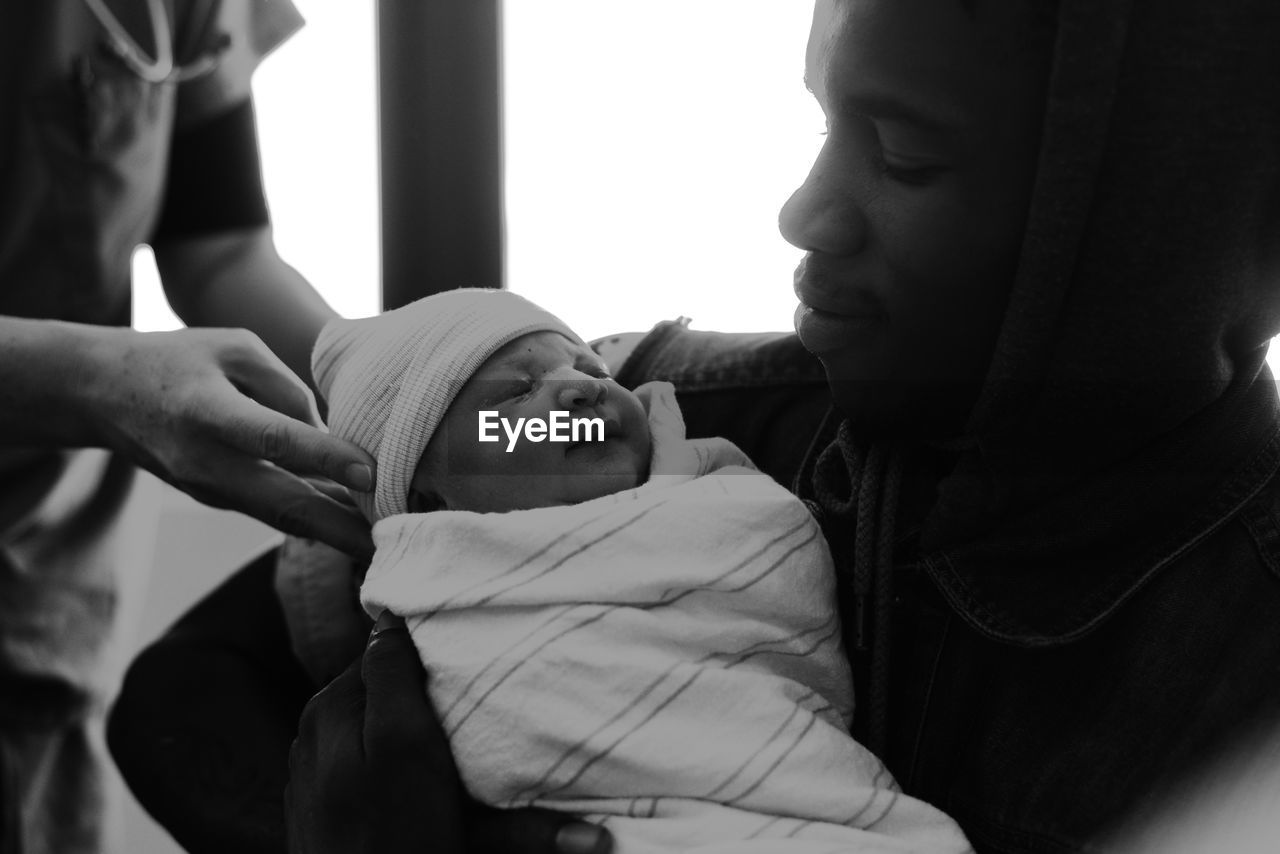 Smiling father carrying cute new born daughter in hospital