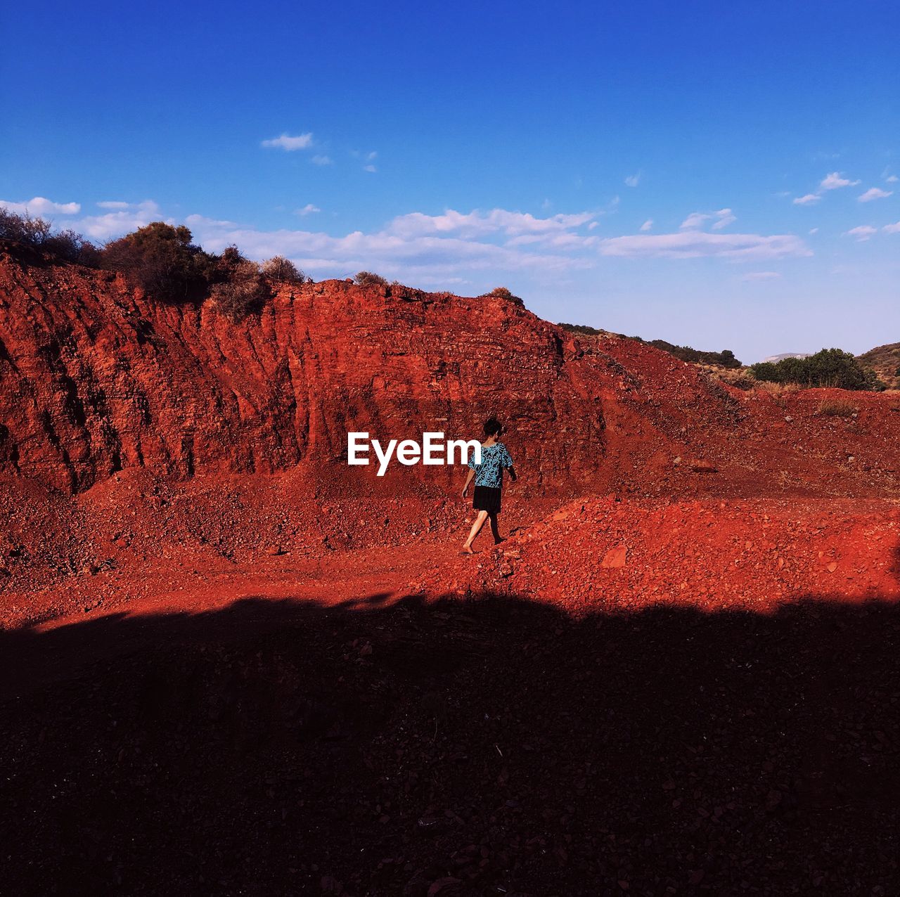 Rear view of woman walking ground against sky