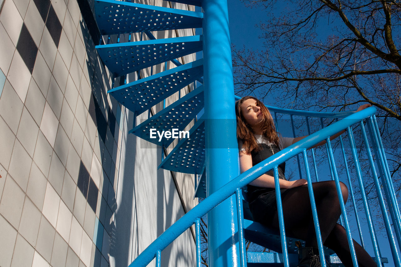 Low angle view of woman looking at railing