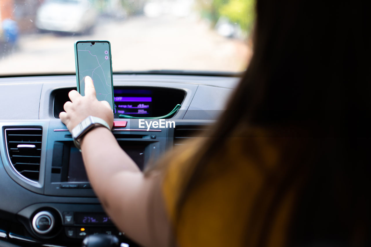 MIDSECTION OF MAN USING MOBILE PHONE