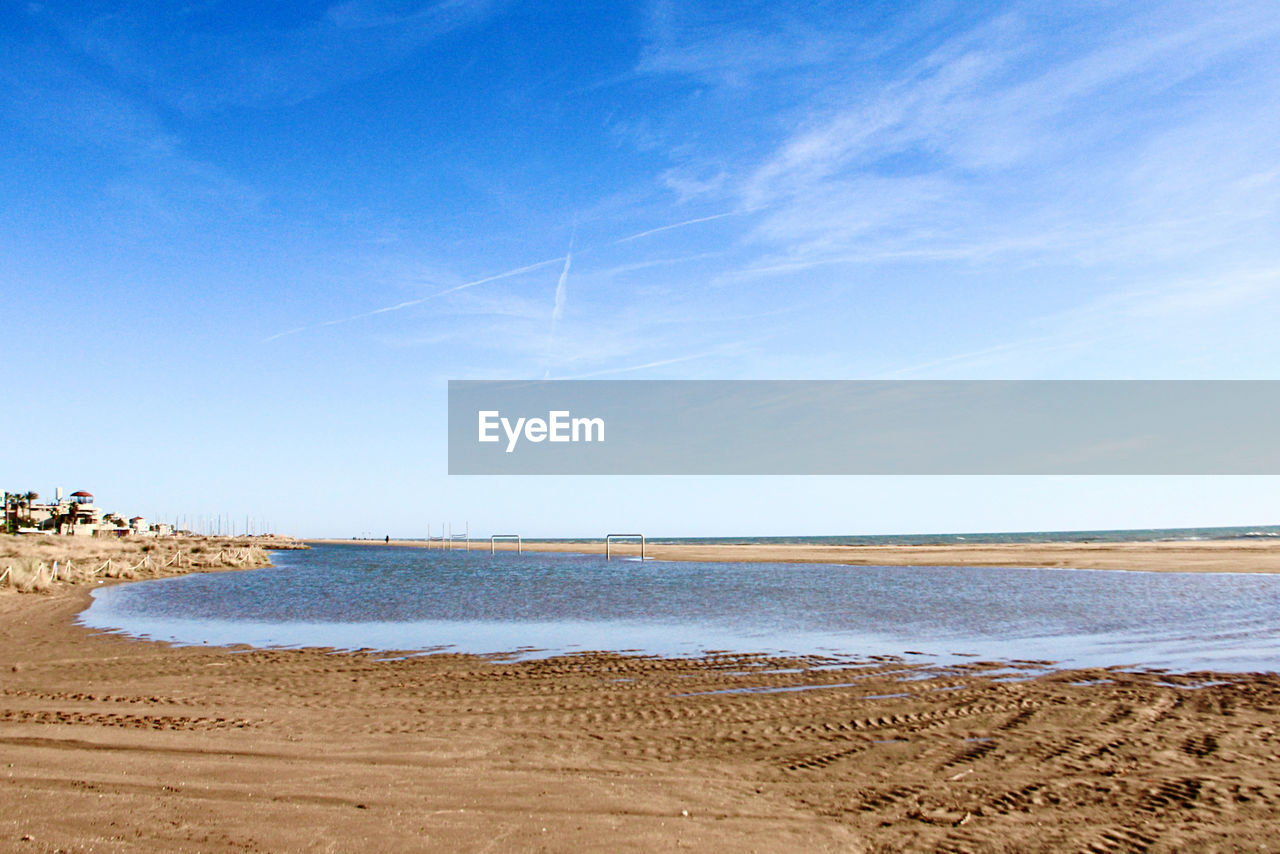 Scenic view of beach against blue sky