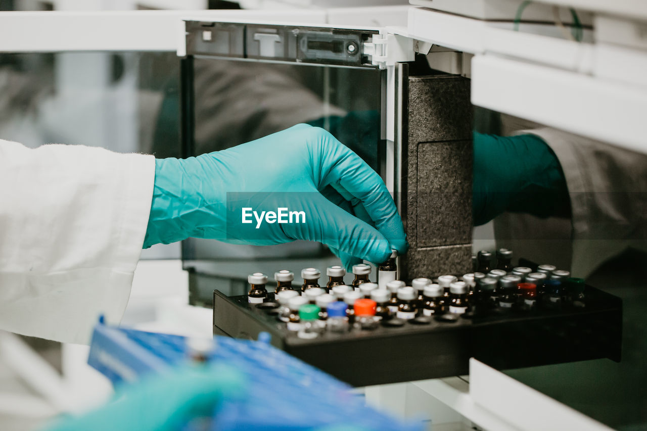 Cropped hand of scientist holding vial in laboratory