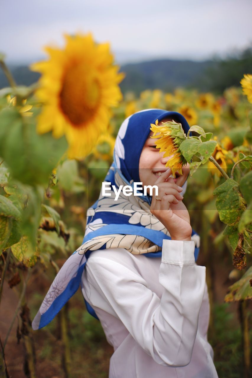 Low angle view of woman on sunflower field