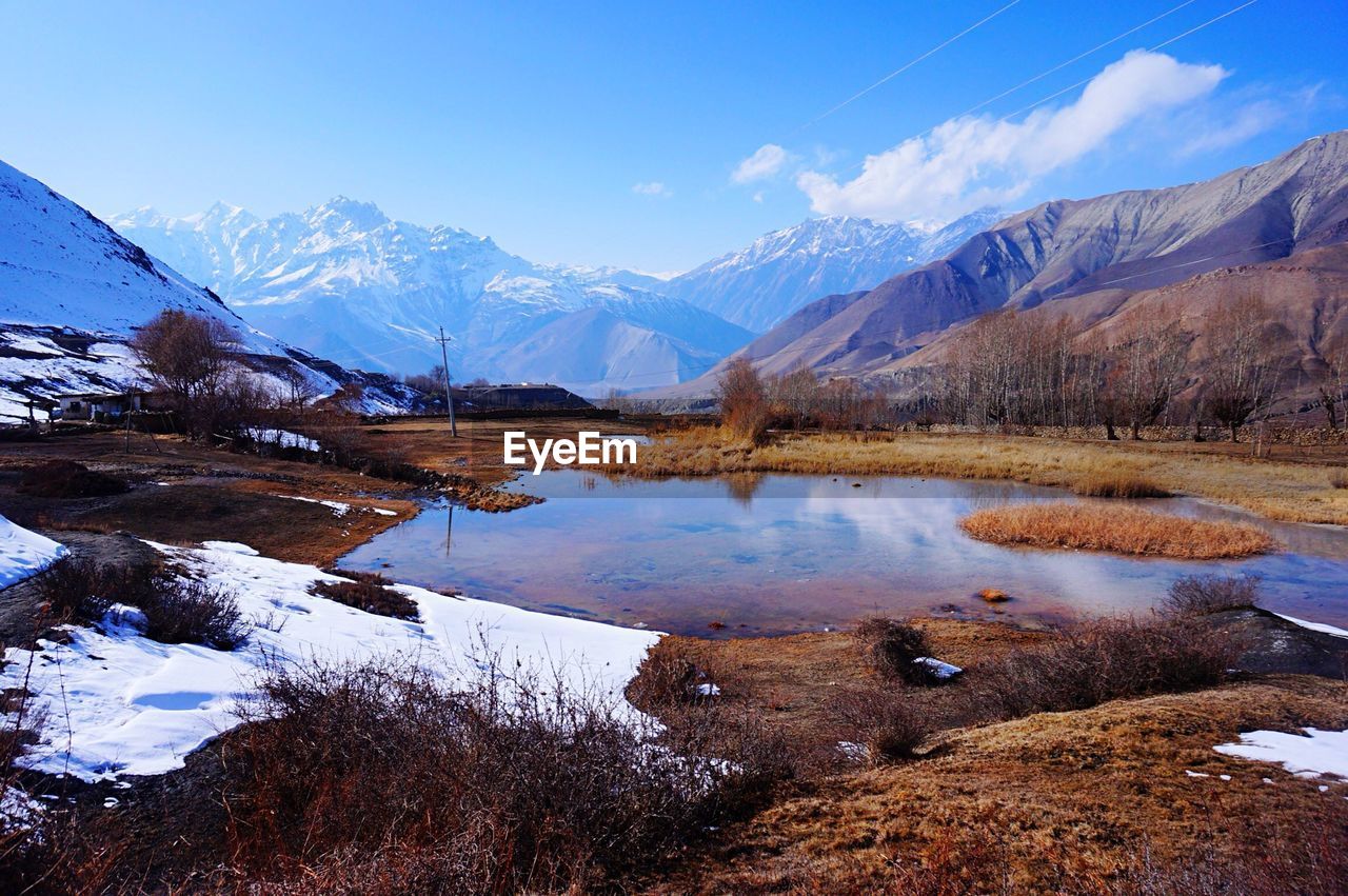 Scenic view of mountains during winter against blue sky