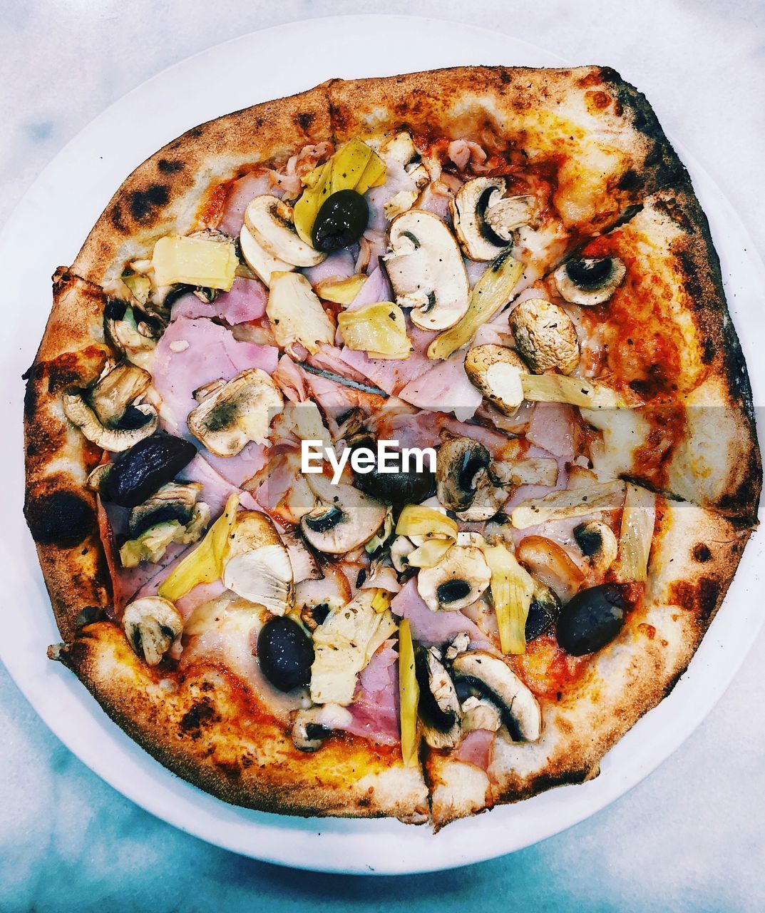 Directly above shot of pizza in plate on wooden table
