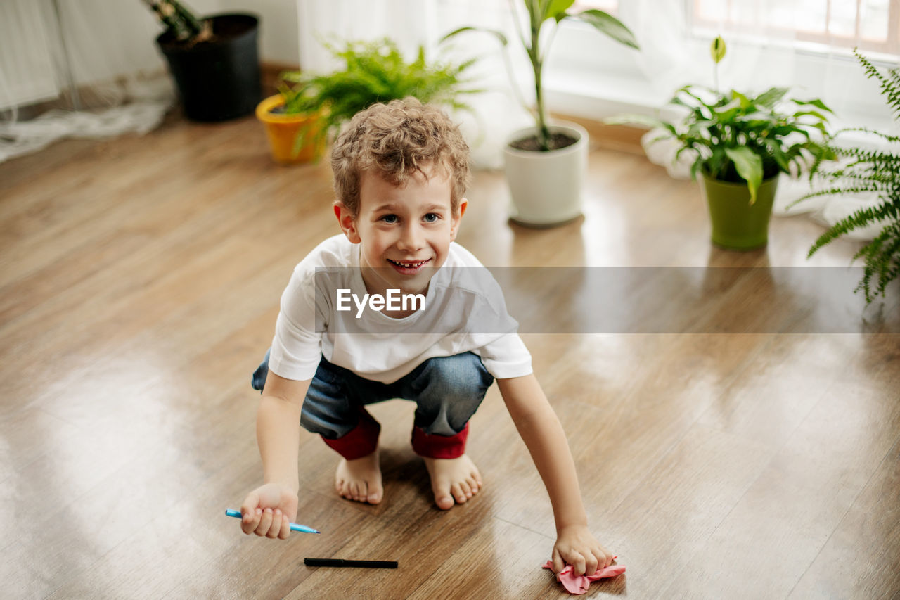 High angle view of boy playing on wooden floor