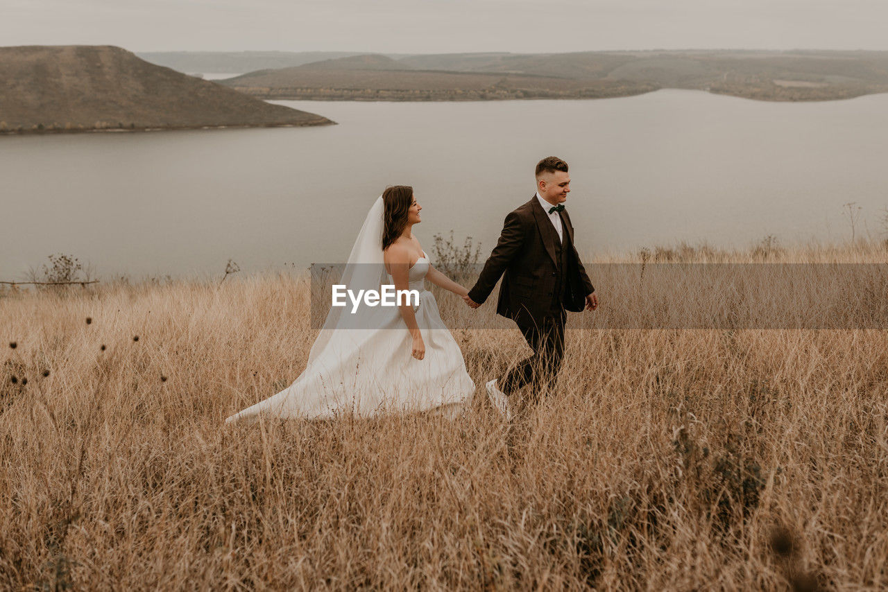 rear view of couple standing on grassy field