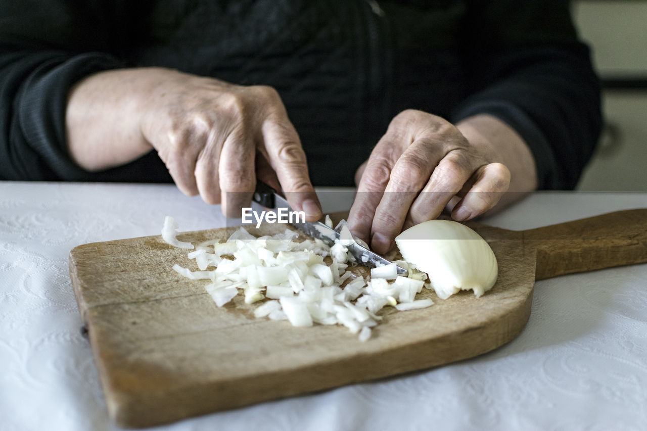 Cropped hand of person preparing food on cutting board