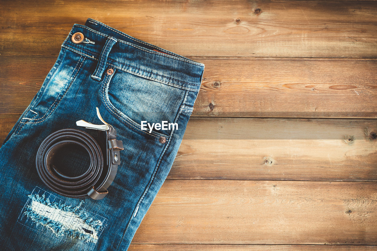 Directly above shot of belt and jeans on table