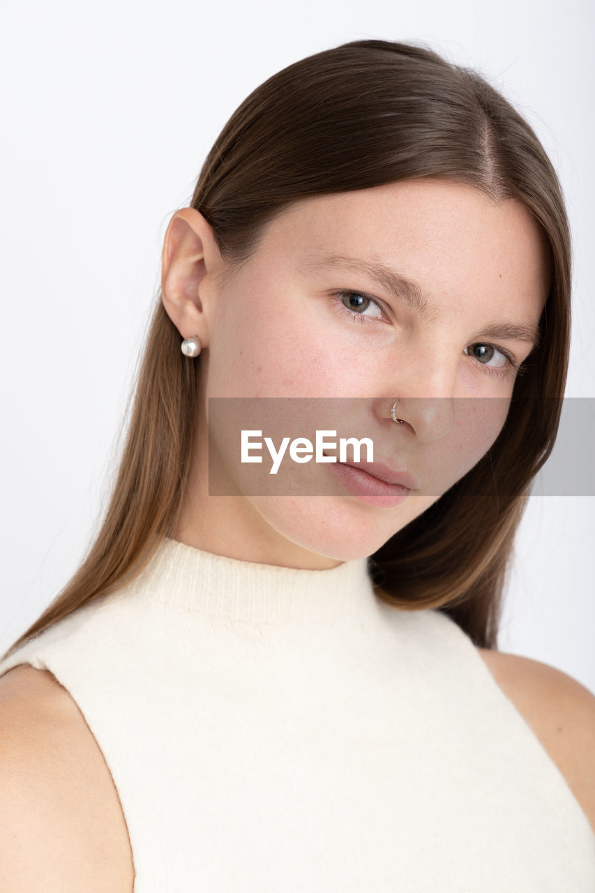 Close-up of young woman against white background