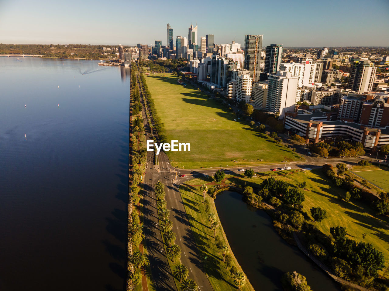 HIGH ANGLE VIEW OF RIVER BY BUILDINGS IN CITY AGAINST SKY