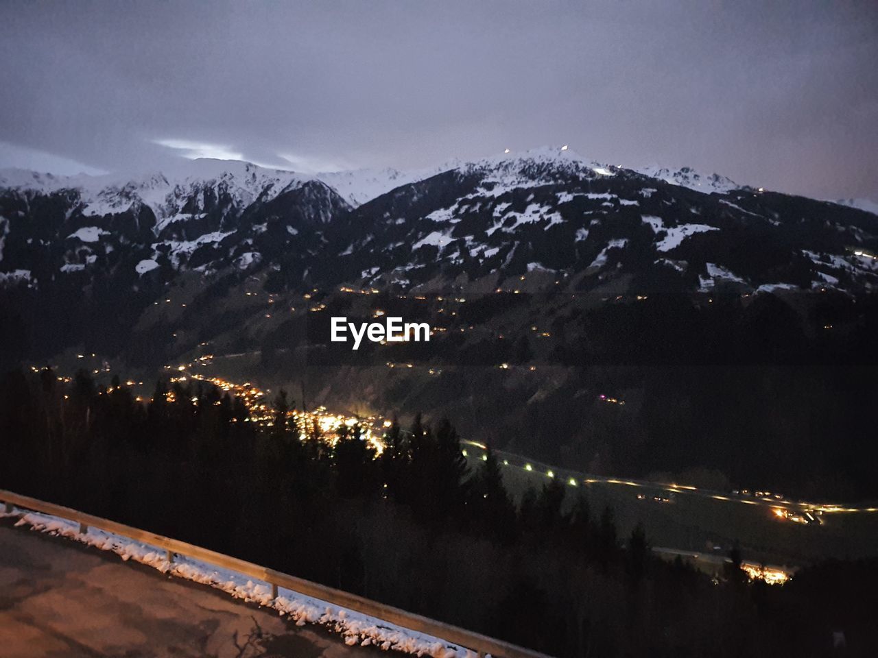 HIGH ANGLE VIEW OF ILLUMINATED MOUNTAINS AGAINST SKY AT NIGHT