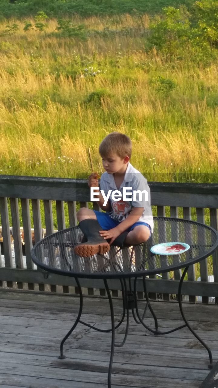 BOY SITTING ON BENCH