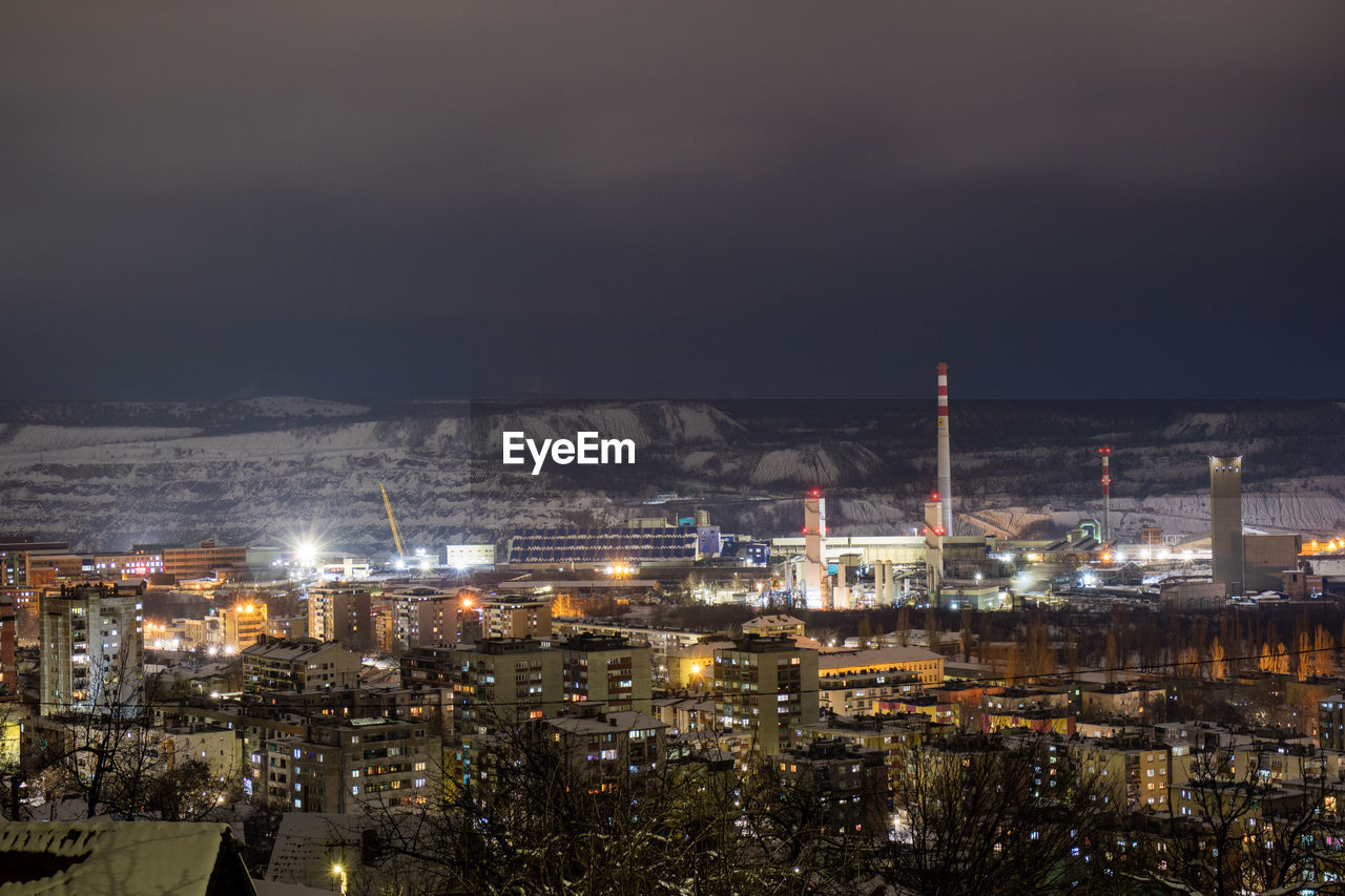 Illuminated cityscape against sky at night