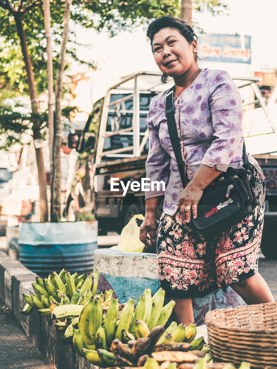 PORTRAIT OF SMILING YOUNG WOMAN STANDING IN MARKET