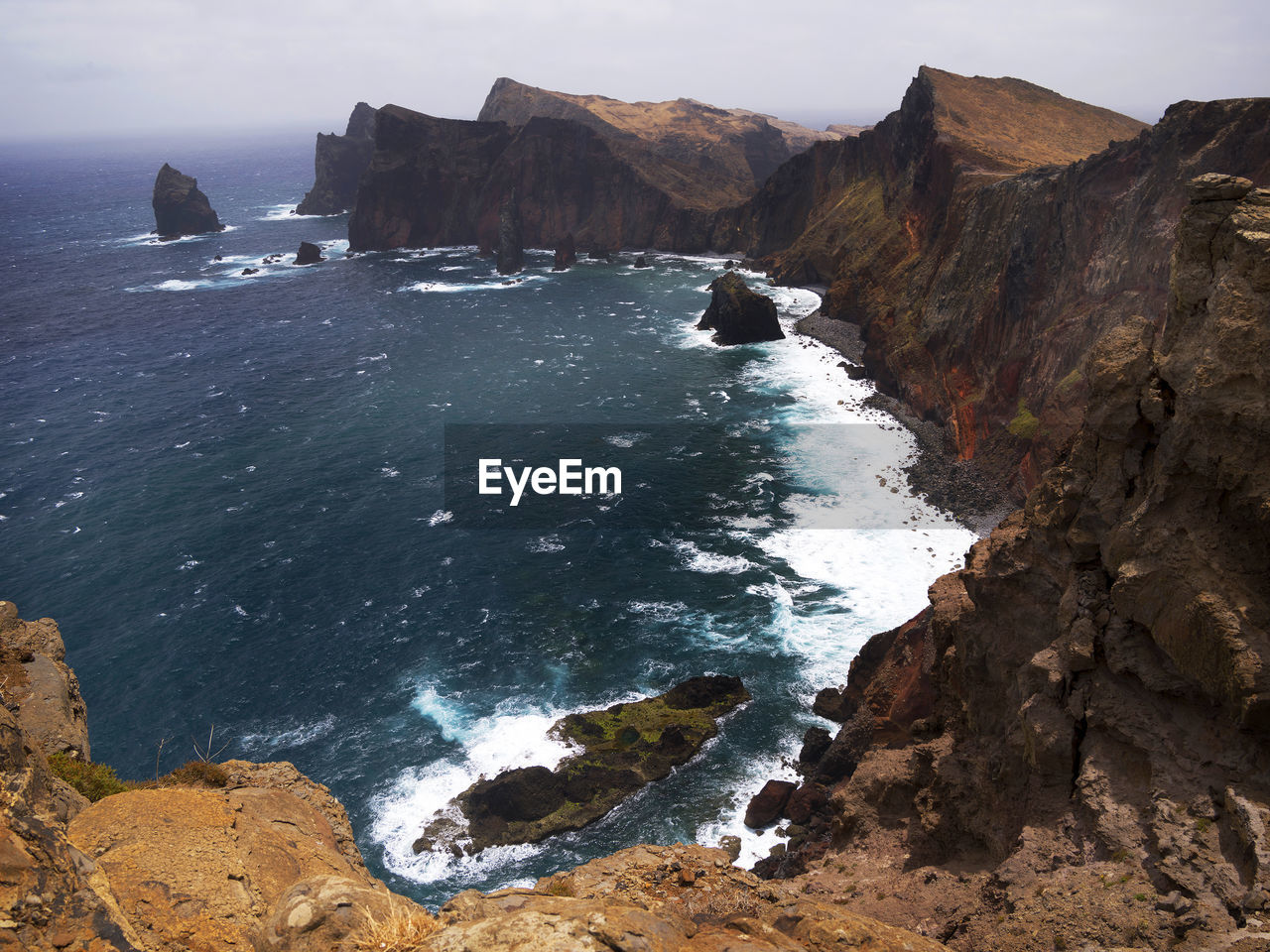 High angle view of rocky coastal feature against sky