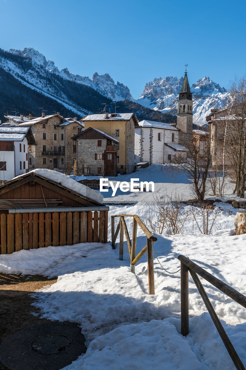 SNOW COVERED BUILDINGS AGAINST SKY