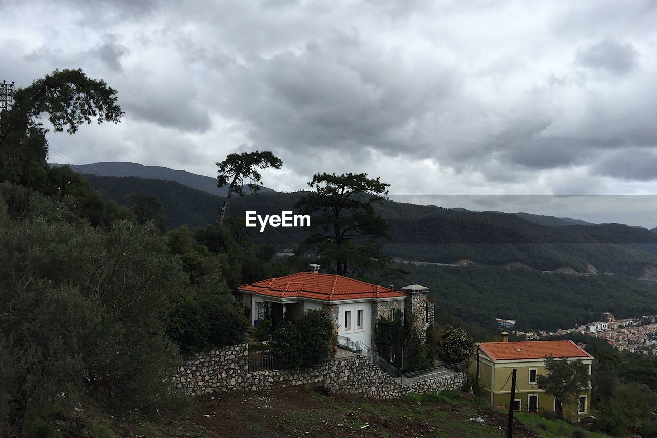 HOUSES BY TREES AGAINST SKY