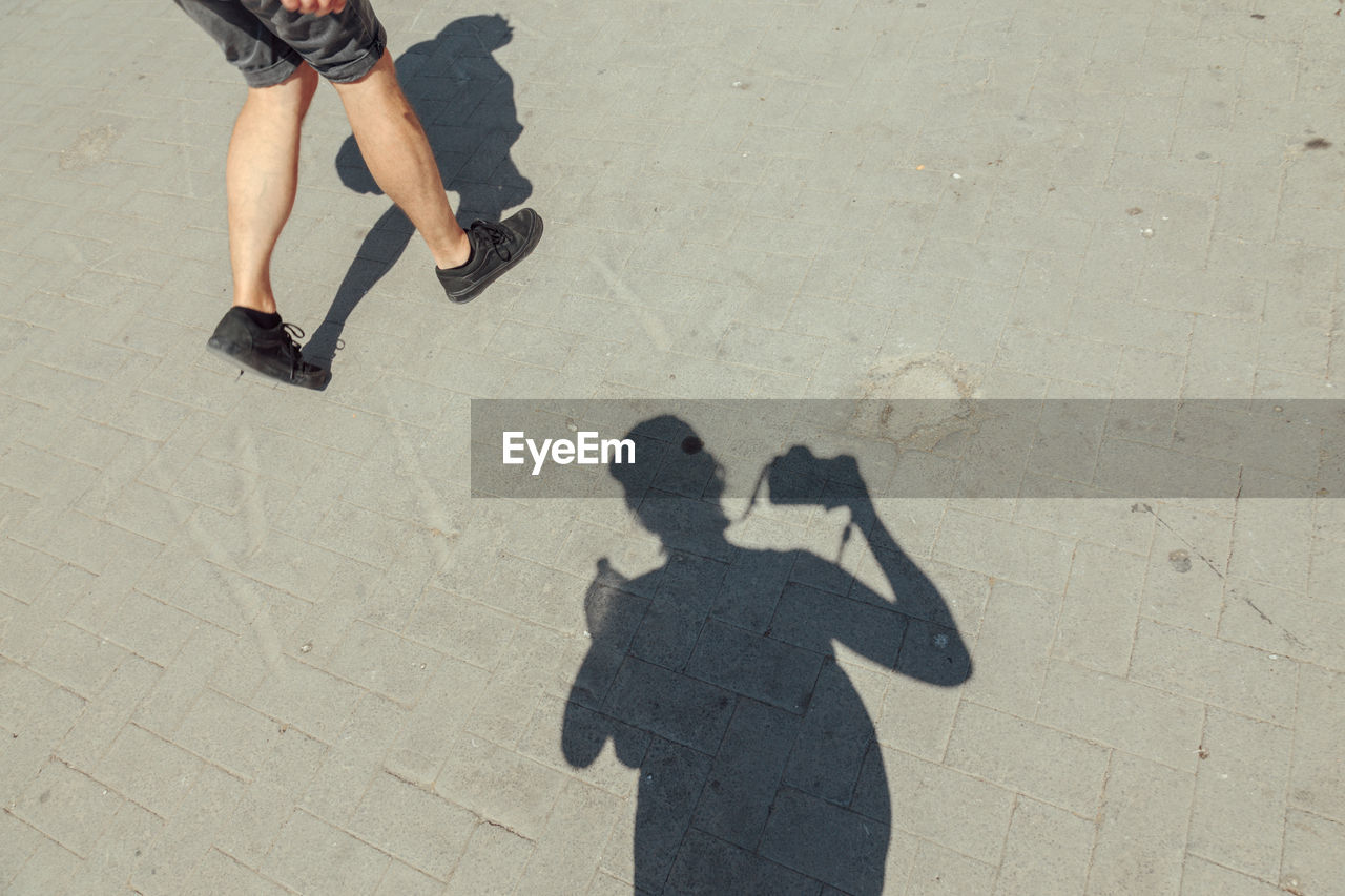 LOW SECTION OF PEOPLE WITH SHADOW ON THE GROUND