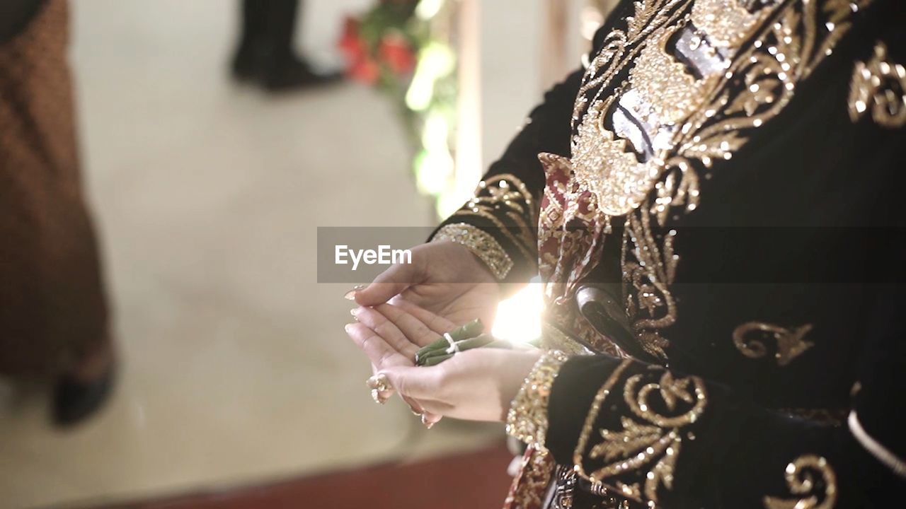 CLOSE-UP OF HANDS AND CROSS ON FINGER